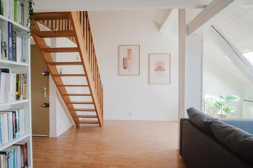 a living room with a staircase and a couch at Duplex proche centre ville in Strasbourg