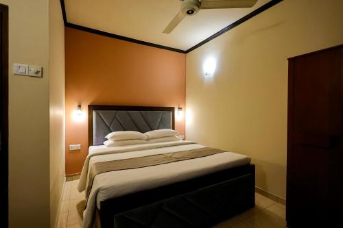 a bedroom with a large bed with orange walls at Limeshine Residence - Airport Transit Hotel in Katunayake