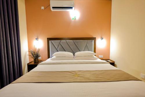 a bedroom with a large white bed with two pillows at Limeshine Residence - Airport Transit Hotel in Katunayake