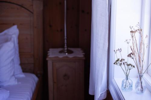 a bedroom with a bed and a lamp on a night stand at Hoel Gård - Herregården ved Mjøsa in Nes i Ådal