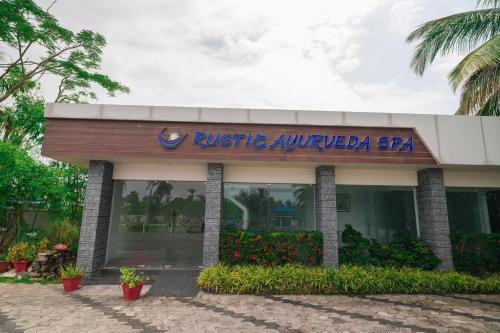 a hotel with a sign on the front of a building at Rustic Leisures Resort in Cochin
