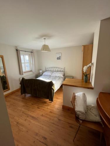 a bedroom with a bed and a wooden floor at Beach Haven Portstewart in Portstewart