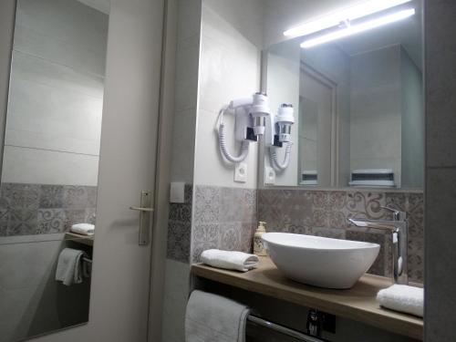 a bathroom with a white sink and a mirror at Castel Fleuri in Tours