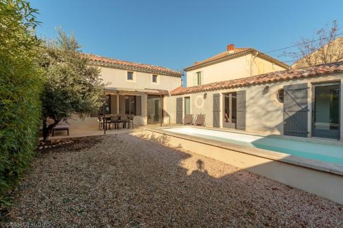 une arrière-cour d'une maison avec une piscine dans l'établissement Mas provençal au coeur de L'Isle-sur-la-Sorgue, à LʼIsle-sur-la-Sorgue