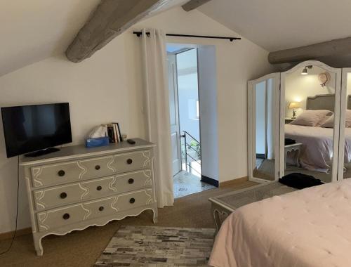 une chambre avec une commode sur laquelle se trouve une télévision dans l'établissement Mas provençal au coeur de L'Isle-sur-la-Sorgue, à LʼIsle-sur-la-Sorgue