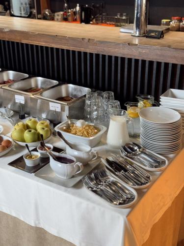 een buffet met kommen en lepels op een tafel bij NeboS Hotel & Restaurant in Ivano-Frankivsʼk