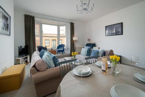 una sala de estar con un sofá y una mesa en The Seagull Apartment, en Cowes