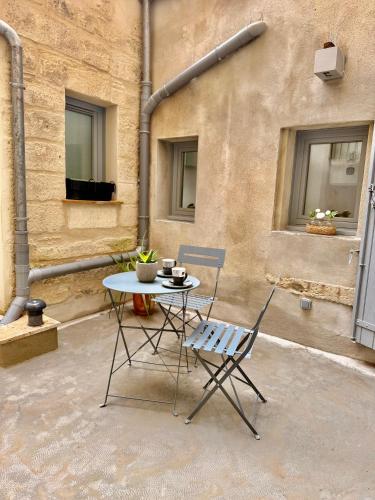 une table et deux chaises assises sur une terrasse dans l'établissement Casbah14 Uzès, à Uzès