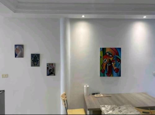 a dining room with a table and a painting on the wall at Sidibou Said Vibes in Sidi Bou Saïd