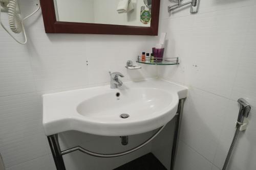 a white sink in a bathroom with a mirror at Rustic Leisures Resort in Cochin