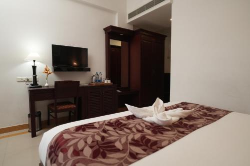 a hotel room with a bed with a flower on it at Rustic Leisures Resort in Cochin