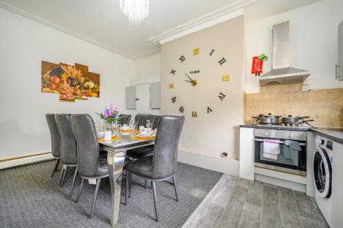 a dining room with a table and chairs and a clock at -RD15CFA- For Relaxed and Cosy stay with Free Parking in Leeds