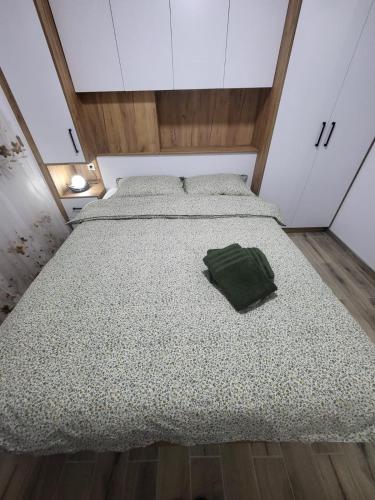 a bed in a room with a green pillow on it at Apartman Aurora in Modriča