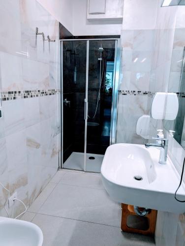 a white bathroom with a shower and a sink at Gardar in Bolzano