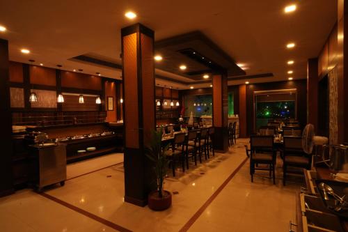 a restaurant with tables and chairs and a bar at Rustic Leisures Resort in Cochin