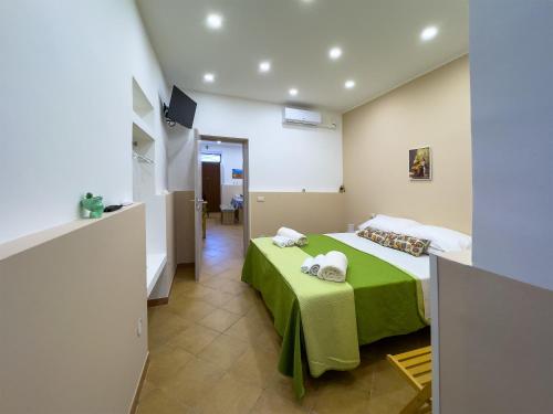 a bedroom with a bed with a green blanket at Le Tre Ninfe - Centro storico Riposto in Riposto