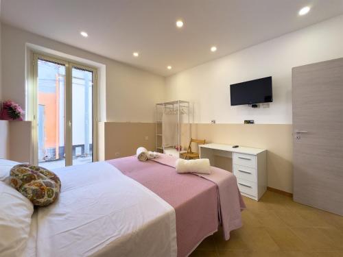 a bedroom with a bed with a tv on the wall at Le Tre Ninfe - Centro storico Riposto in Riposto