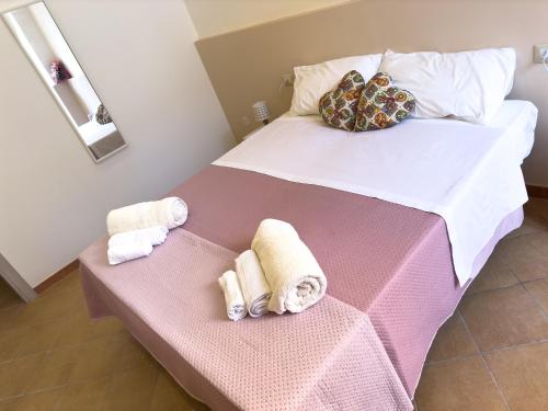 a bedroom with a bed with towels on it at Le Tre Ninfe - Centro storico Riposto in Riposto