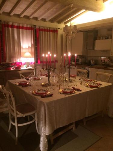 a dining room table with a white table cloth and candles at La Macina di Modì in Cetona