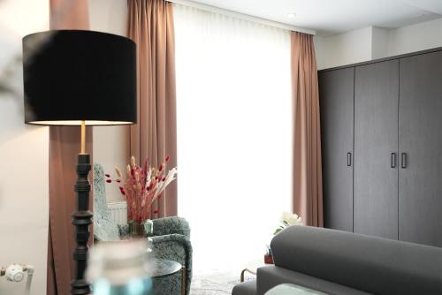 a living room with a couch and a lamp at Hotel Palmenhof in Frankfurt/Main