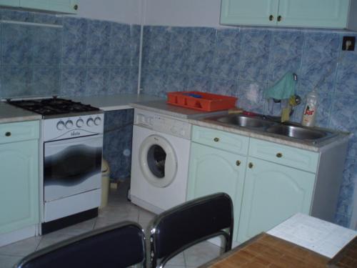 a kitchen with a washing machine and a sink at Belvárosi Vendégház in Miskolc