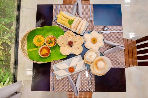 a table with a green plate of food on it at Limeshine Residence - Airport Transit Hotel in Katunayake