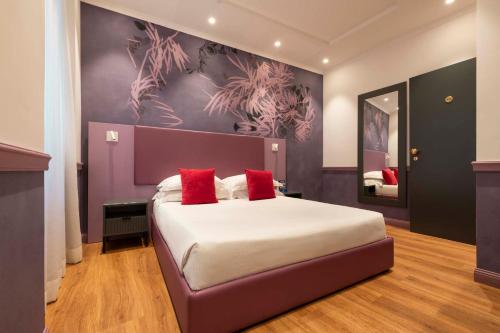 a bedroom with a large bed with red pillows at Atlante Star Hotel in Rome