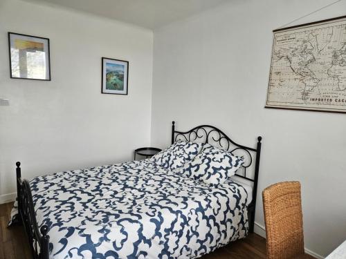 a bedroom with a black and white bed and a map at Maison au calme 2 logements Guéret in Guéret