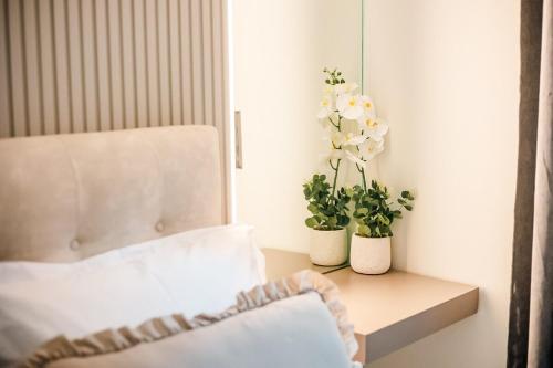 a bedroom with a bed and two vases with flowers at Sunset luxury studio by the sea in Athens