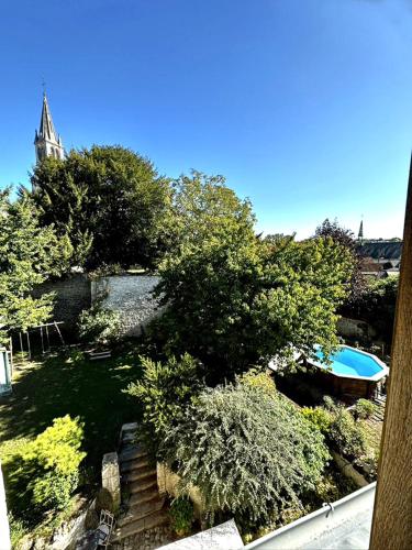 - une vue sur une cour avec une piscine et des arbres dans l'établissement Aquarelle, à Sainte-Maure-de-Touraine