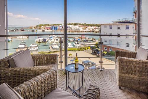 a balcony with two chairs and a table with a bottle of wine at Saltwater apartment in Cowes