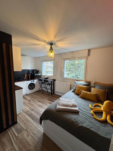 a bedroom with a large bed and a kitchen at L'Escale - 300 m Océan - Hyper Centre - Lumineux - Garage Privatif in Saint-Nazaire