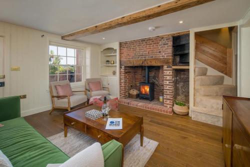 un salon avec un canapé et une cheminée dans l'établissement Honeybee Cottage, à Cowes
