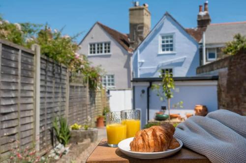 une table avec une assiette de pain et de jus d'orange dans l'établissement Honeybee Cottage, à Cowes