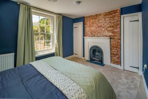 a bedroom with a brick fireplace and a bed at Honeybee Cottage in Cowes