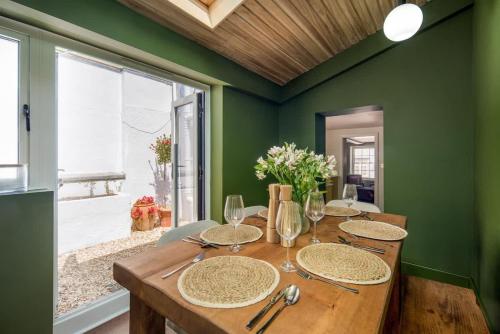 a dining room with a wooden table and green walls at Honeybee Cottage in Cowes