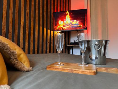 two wine glasses on a table in front of a tv at L'Escale - 300 m Océan - Hyper Centre - Lumineux - Garage Privatif in Saint-Nazaire