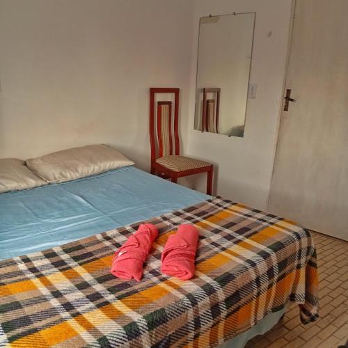 two red pillows sitting on a bed in a room at Newen Hospedagem in Arraial do Cabo