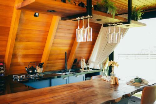 a kitchen with wooden walls and a wooden table at Alpinada Cabanas in Carlos Barbosa
