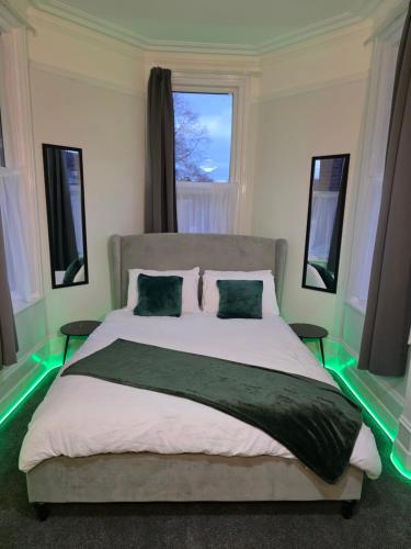 a bedroom with a large bed with green lights at Spacious - 8ight Havens Folkestone in Folkestone