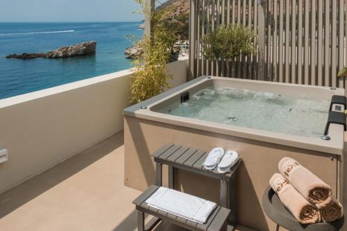 a jacuzzi tub on the balcony of a house at Folie Marine Hotel & Beach Club in Jal