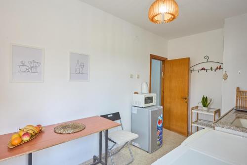 une petite cuisine avec une table et un réfrigérateur dans l'établissement צימר גל 27 - צימר מקסים עם ג'קוזי מול נוף מדברי מהמם, à Arad