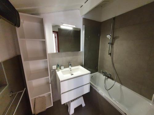 a bathroom with a sink and a bath tub at Zeegalm Bungalows in Middelkerke
