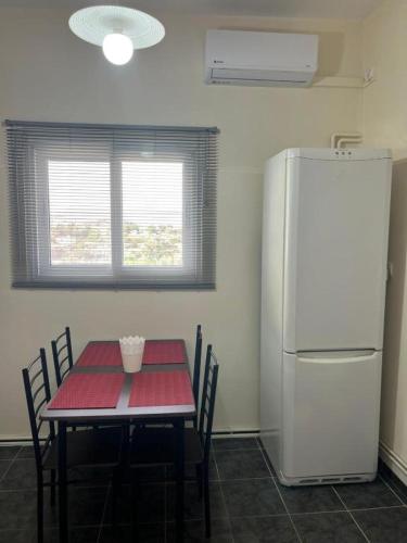 a kitchen with a table and a white refrigerator at Casa Di Mario Rooms in Lávrion