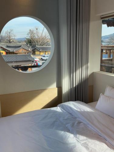 a bedroom with a bed and a round window at Gyeong-ju Stayangim in Gyeongju
