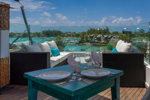 a table on a balcony with a view of a pool at Azur Paradise Hotel & Rooftop Bar in Grand Baie