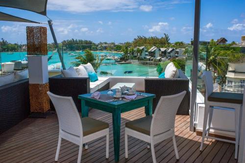 a table and chairs on a balcony with a view of a pool at Azur Paradise Hotel & Rooftop Bar in Grand Baie