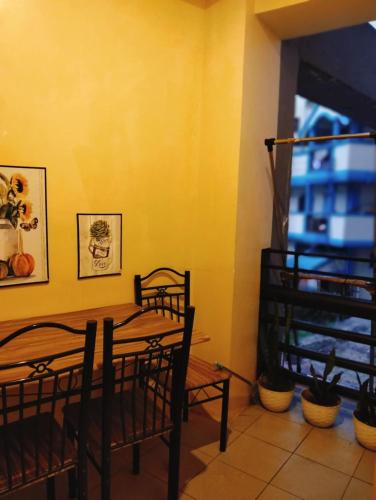 a dining room with a table and chairs and a window at Goshen Land Towers Baguio in Baguio