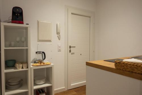 a kitchen with a door and a counter with plates at Apartamentos El Aljibe in Badajoz