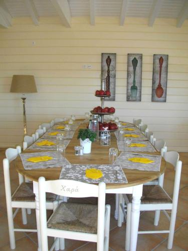 a long table with white chairs and a long table with food on it at Ktima Noosfera Wellness & Retreat Center in Nees Vrisoules